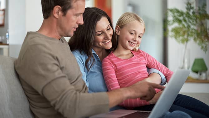 私人博客可以阻止陌生人了解您家的个人详细信息。图像显示两位父母和女儿坐在沙发上，一起看着平板电脑。