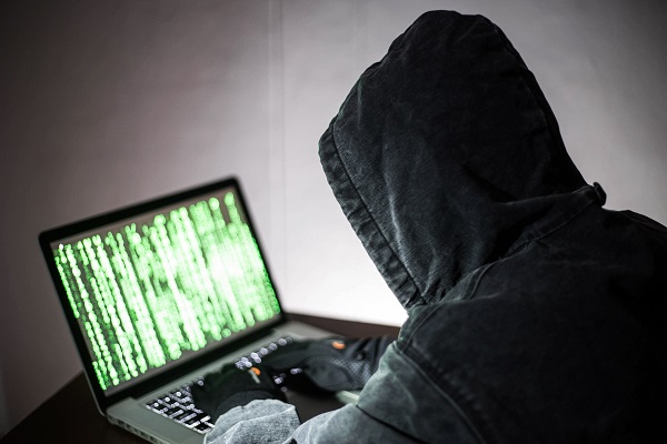 一位正在计算机前工作的男士发现自己被黑客入侵了，感到非常苦恼。